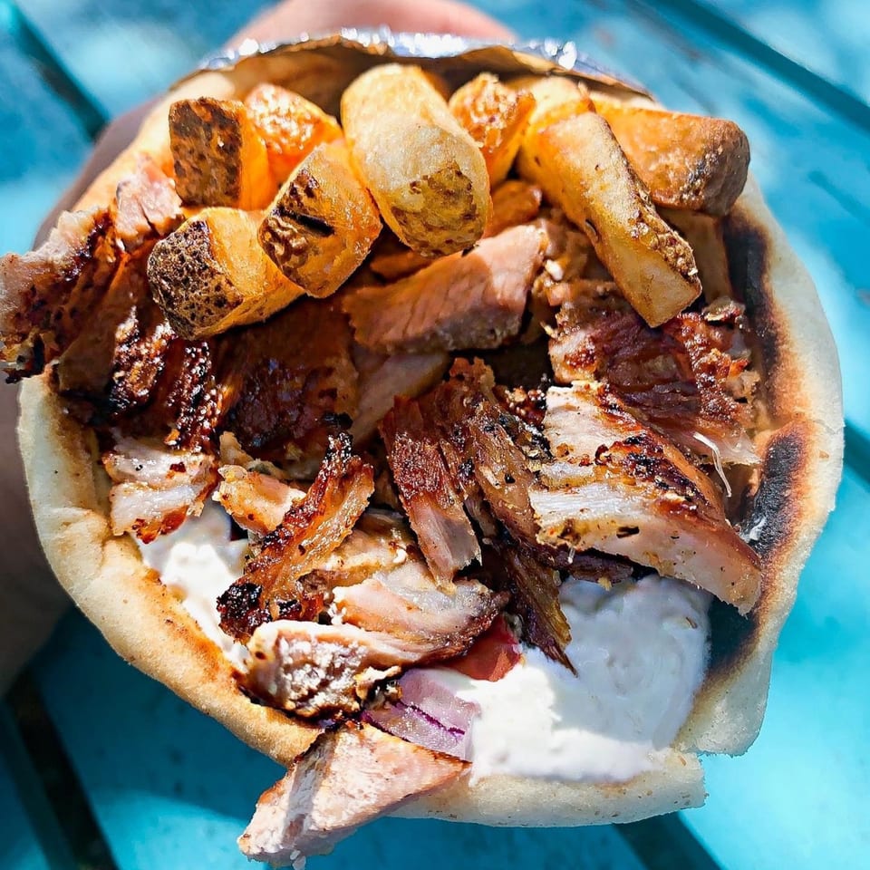 A My Big Fat Greek Trailer gyro with grilled meat, fries, and tzatziki sauce.